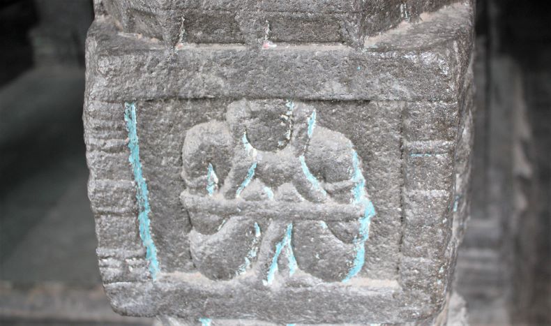 Vaman stambha No. 2: A yogī carved holding his hand on his ear.