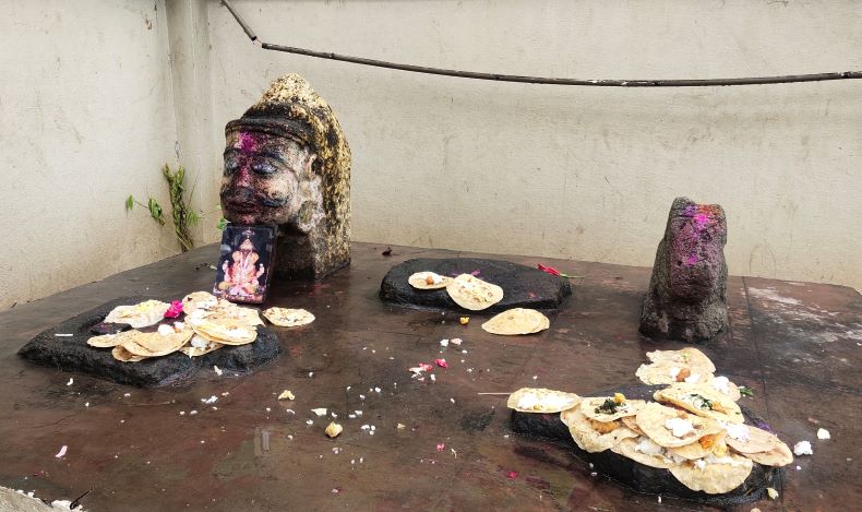 A foot impression (probably a burial insignia), Śivaliṅga, Nandī, and one human head on a pedestal.